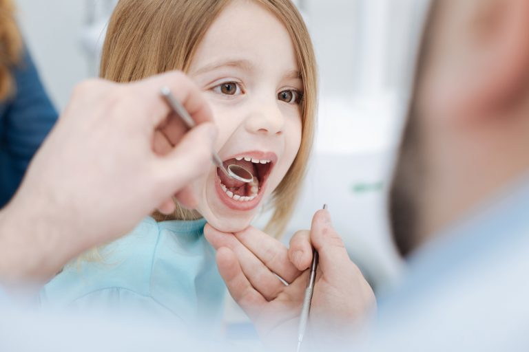 Obedient cute child holding her mouth open